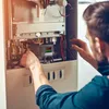 A person is working on a thermostat regulator inside a heating or cooling system. Produktbild-Vorschau