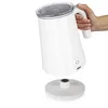 A hand holding a white electric milk frother over its base. Produktbild-Vorschau