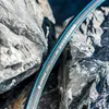 A close-up shot of a garden hose resting on rocks. Voir les images du produit