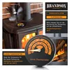 A stove fan and thermometer are shown next to a wood-burning stove with a fire inside. Produktbild-Vorschau