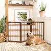A golden retriever dog lies on a rug in front of a wooden pet gate, with stairs and a plant in the background. Podgląd zdjęcia produktu