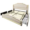 A disassembled beige upholstered bed frame with a headboard, slats, and drawers pulled out. Produktbild-Vorschau