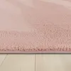 A close-up view of a pink rug with a textured surface, resting on a light-colored wooden floor. Produktbild-Vorschau