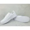 A pair of white Adidas sneakers are displayed on a light gray concrete surface. Anteprima dell’immagine prodotto