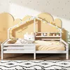 A child's bed with a house frame and decorative lights, set in a room with a playful wallpaper and rug. Produktbild-Vorschau