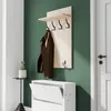 A coat rack with a shelf and hooks, a brown jacket hanging on it, a small plant, and a shoe cabinet are shown against a green wall. Voir les images du produit