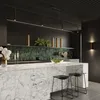 A modern kitchen with a marble island and green tiled backsplash. Voir les images du produit