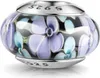 Schwarzer Glas Bead mit lilanem und blauen Blumenmuster, in silberner Hülse mit 925 Prägung, liegend fotografiert auf weißem Hintergrund. Produktbild-Vorschau