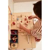 A child is playing with a wooden toy workbench. Produktbild-Vorschau