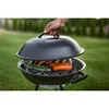 A hand is lifting the lid of a black charcoal grill with food cooking on the grate. Produktbild-Vorschau