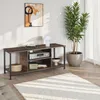 A TV stand with media components and decorative items in a living room setting. Produktbild-Vorschau