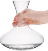 A hand holding a glass decanter with cleaning beads at the bottom. Anteprima dell’immagine prodotto
