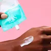 A hand is applying cream from a tube onto another hand. Produktbild-Vorschau