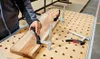 A person is using clamps to hold a piece of wood on a workbench. Náhľad obrázku produktu