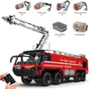A detailed view of a remote-controlled fire truck model with various components and accessories laid out. Voir les images du produit