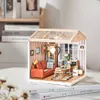 A miniature dollhouse room with furniture and accessories, displayed on a stack of books. Anteprima dell’immagine prodotto