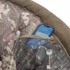A close-up view of a pocket on a camouflage-patterned chair, showing a smartphone and keys inside. Produktbild-Vorschau