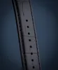 A close-up of a black watch strap with visible stitching and holes for adjustment. Voir les images du produit