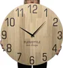 A person holding a large wooden wall clock. Voir les images du produit