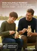 A father and son are sitting outdoors, carving small wooden bears. Produktbild-Vorschau