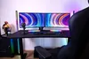 A gaming desk setup with dual monitors, a keyboard, microphone, and a gaming chair. Voir les images du produit