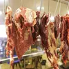 Several pieces of raw meat are hanging from hooks. Produktbild-Vorschau