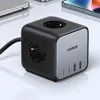 A black and silver Ugreen power strip cube with multiple USB ports and AC outlets, shown on a reflective white surface. Produktbild-Vorschau