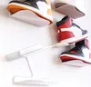 Several pairs of sneakers are displayed on white wall-mounted shelves. Produktbild-Vorschau