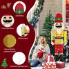 A woman sits in front of a large, illuminated nutcracker decoration during what appears to be a winter or Christmas setting. Produktbild-Vorschau