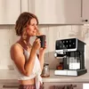 A woman is enjoying a cup of coffee in a kitchen next to a coffee machine. Produktbild-Vorschau