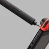 A close-up shot of an electric screwdriver being used to unscrew a red and black electronic device. Náhled obrázku produktu