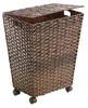 A brown woven laundry basket with a lid and wheels, shown against a white background. Náhled obrázku produktu