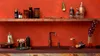 A kitchen counter with a sink, faucet, and various barware items, set against a vibrant red wall. Podgląd zdjęcia produktu