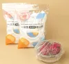 Two bags of disposable food covers and a bowl of dragon fruit covered with a plastic wrap. Produktbild-Vorschau