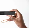 A hand holds a black Invoxia GPS tracker with a leather strap. Náhľad obrázku produktu