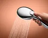 A hand is holding a chrome shower head with water spraying out. Anteprima dell’immagine prodotto