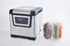 A sous vide cooker with vacuum-sealed food items in a rack next to it. Produktbild-Vorschau