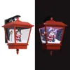 A split image showing a red Christmas lantern with a Santa Claus figurine inside. The left side is on a white background and the right side is on a black background, with the lantern illuminated on the right. Náhľad obrázku produktu