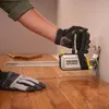 A person wearing gloves is using a Stanley Fatmax clamp tool to install wooden flooring. Náhľad obrázku produktu