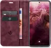A burgundy flip-case wallet for a smartphone is shown open, displaying the phone's screen and card slots with cards and banknotes. Produktbild-Vorschau