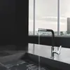 A modern kitchen sink with a faucet running water, with a city view through a large window in the background. Produktbild-Vorschau