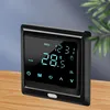 A digital thermostat is placed on a wooden table with a blurred background of a blue wall and a plant. Náhled obrázku produktu