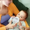 A mother is feeding her baby with a bottle. Voir les images du produit
