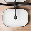 A top-down view of a rectangular white sink with a black rim, mounted on a wooden surface. A black faucet is visible in the center. Náhled obrázku produktu