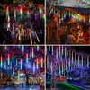 A collage of four images showing colorful LED meteor shower lights decorating trees and a building. Náhled obrázku produktu