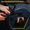 Close-up of a person's hands adjusting the pedal strap of a stationary bike, with a smaller inset image showing a hand holding a cylindrical object. Produktbild-Vorschau