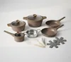 A collection of cookware and kitchen utensils arranged on a white surface. Voir les images du produit