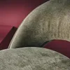 A close-up view of the textured fabric of a chair or stool, with a blurred red background. Produktbild-Vorschau