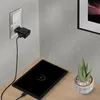 A tablet is charging on a wooden desk next to a potted plant. A power adapter is plugged into a wall socket and connected to the tablet. Produktbild-Vorschau