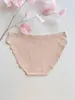 Beige nahtlose Damenunterwäsche mit dezentem Markenlogo auf weißem Hintergrund, neben einem rosa Deko-Zweig Produktbild-Vorschau